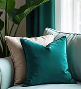Decorative throw pillows arranged on furniture, featuring solid teal and textured neutral pillows creating a modern accent display.